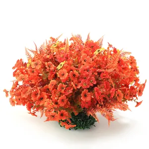 Autumn harvest hanging basket with artificial flowers and orange foliage on white background