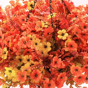 Detail of hanging basket with orange flowers, green ferns, and black metal chain