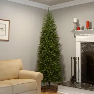 Tall slim green pencil Christmas tree with dense PVC needles in a cozy living room scene