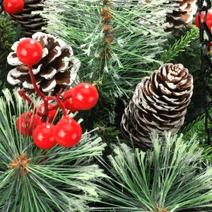 Dettaglio di cesto natalizio con aghi di pino, bacche rosse e pigne con effetto neve