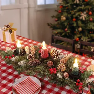 Centre de table Noël avec aiguilles de pin, baies rouges, cônes et trois bougies sapin