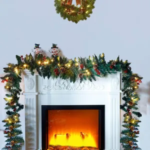 Christmas garland and wreath with pine cones red berries and LED lights on white fireplace