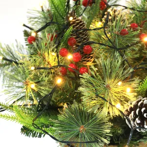 Dettaglio di cesto natalizio con LED caldi, bacche rosse e pigne con effetto neve