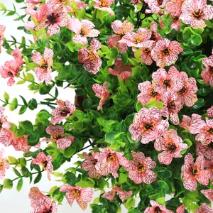 Close-up of pink faux flowers with purple veins and lush green leaves for garden hanging baskets