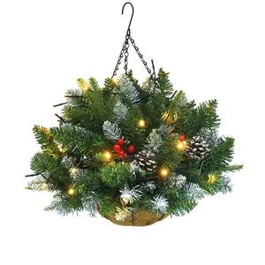 Cesto natalizio appeso con aghi di pino, bacche rosse e calde luci a LED decorative