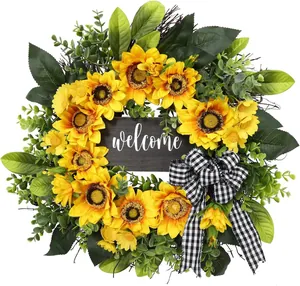 Close-up of artificial sunflower wreath with a black and white bow and welcome sign