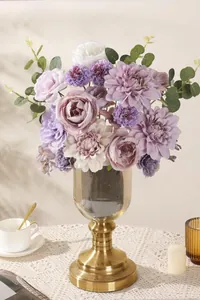 Purple artificial silk bouquet in gray glass vase on lace tablecloth for wedding decor