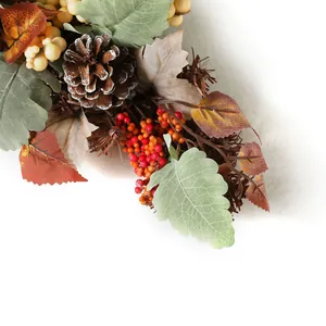 Detail of harvest wreath featuring pine cones, colorful maple leaves and red berries