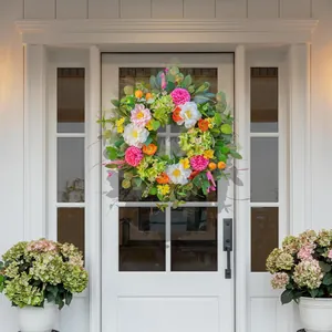 Artificial wildflower wreath with pink dahlias and white peonies on a white front door