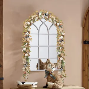 Close-up of fall garland with white pumpkins, maple leaves, and striped bows on mirror