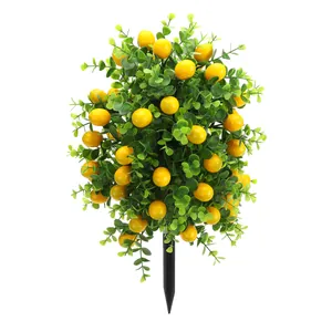 Close-up of artificial lemon topiary ball with green leaves and yellow berries on garden stake