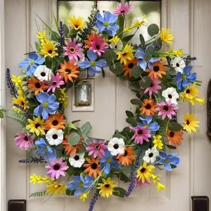 Colorful spring daisy and sunflower wreath hanging on a white door for home decoration