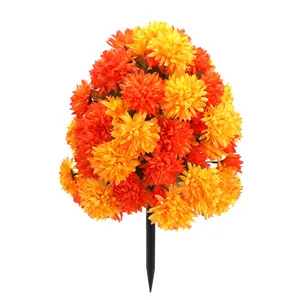 Macro shot of artificial orange and yellow daisies with a ground spike for garden decor