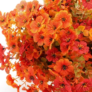 Künstliche violette Ampel mit herbstlichen orangen Blumen und Eukalyptusblättern