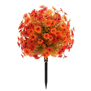 Artificial orange violet flower ball with green leaves on a black garden ground stake