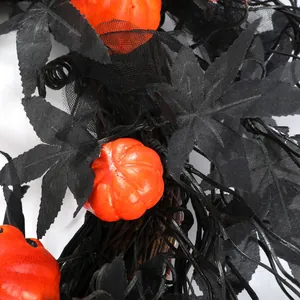 Halloween wreath with black maple leaves and orange mini pumpkins on a white background