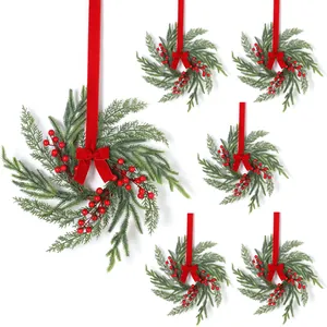 Detail of 6-piece Christmas wreath set with green pine needles, red berries and velvet bows