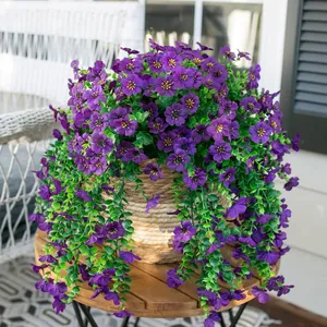 Detailansicht lila Kunstblumen im geflochtenen Topf auf einem Holztisch im Freien