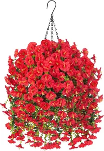 Dettaglio di fiori artificiali rossi appesi con foglie verdi e catena in metallo nero