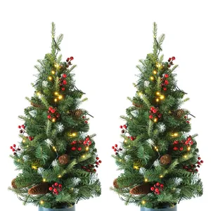 Close-up of 90cm artificial Christmas trees with pine cones, red berries and LED lights