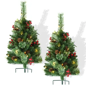 Détail du sapin de Noël enneigé avec lumières LED chaudes, pommes de pin et baies