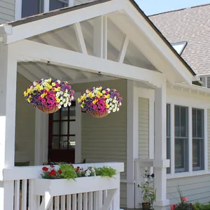 Hanging basket with colorful artificial petunias and eucalyptus in white porch
