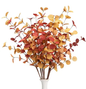 Detailed view of artificial autumn eucalyptus stems with realistic red and orange leaves