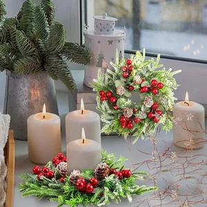 Gros plan d'une couronne de bougie de Noël avec baies rouges, aiguilles et pommes de pin
