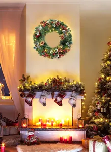 Couronne de Noël avec pommes de pin et baies rouges sur cheminée avec LED