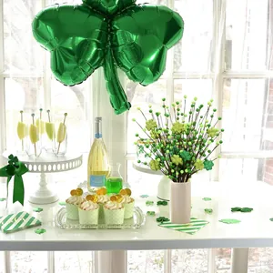 Deko zum St. Patrick's Day mit Kleeblatt-Zweigen, grünen Ballons und Party-Accessoires