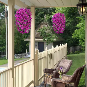 Detail view of two hanging baskets with vibrant magenta silk bougainvillea on a porch