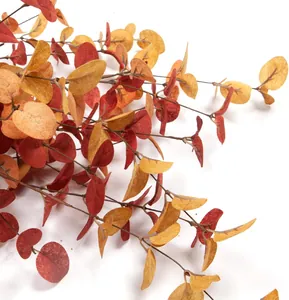 Detailed view of artificial eucalyptus stems with deep red and orange autumn leaves