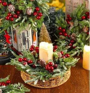 Détail d'un centre de table couronne de Noël avec baies rouges et pommes de pin