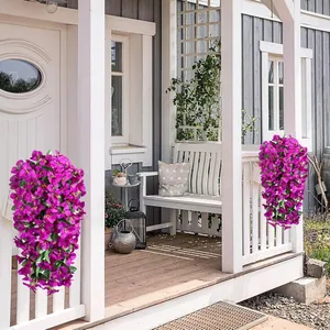 Vibrant purple artificial bougainvillea flowers hanging on a white wooden porch post