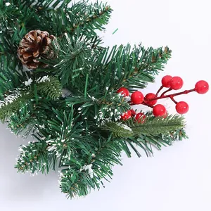 Green Christmas garland with natural pine cones, red berries and realistic artificial snow