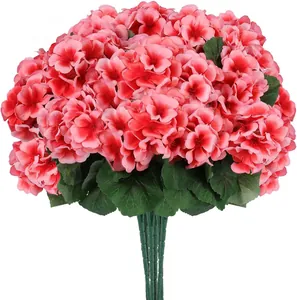 Détail de fleurs de géranium artificielles en soie rose avec feuilles vertes réalistes