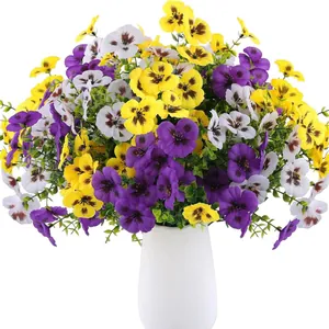 Artificial pansies in yellow, purple, and white within a minimalist white ceramic vase