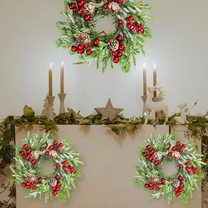Vue détaillée des couronnes de Noël avec baies rouges, pommes de pin et effet de neige