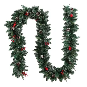 Artificial Christmas garland with red berries, pine cones and snow-flocked needles