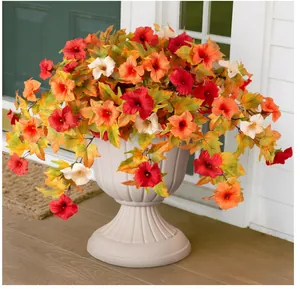 Décoration de porche avec hibiscus artificiels rouges dans un pot romain blanc élégant