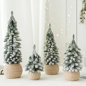 Four mini flocked tabletop cedar Christmas trees with snow effect and woven bases