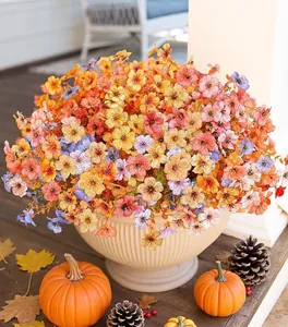 Petunias in ceramic pot with autumn pumpkin and maple leaves decoration detail
