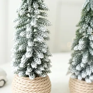 Miniature flocked cedar Christmas trees with snow effect and woven bases for desk decor