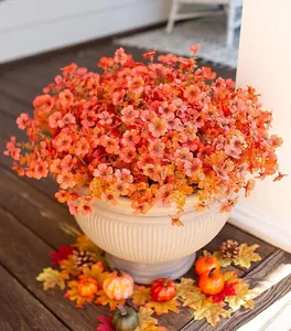 Detailed close-up of orange faux flowers in a white ribbed bowl for autumn home decor