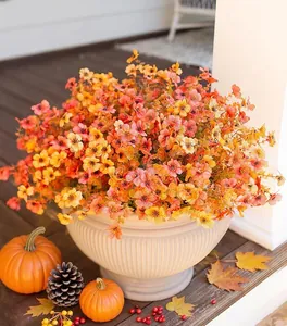 Detail of artificial autumn bouquet with orange flowers and pumpkin in ceramic pot