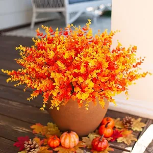 Detail of artificial eucalyptus plant with autumn orange leaves in a ceramic pot