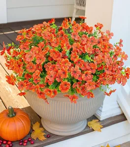 Vibrant orange artificial petunia flowers in a grey striped pot for autumn garden decor