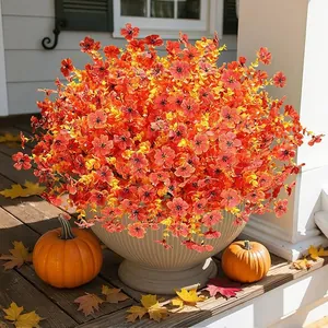Vibrant orange artificial morning glory flowers in a white fluted pot on a porch