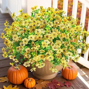 Close-up of yellow artificial petunia flowers in brown pot with autumn pumpkin decor