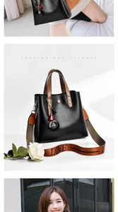 Detail of black pebbled leather bucket bag with brown handle and LOVE patterned strap